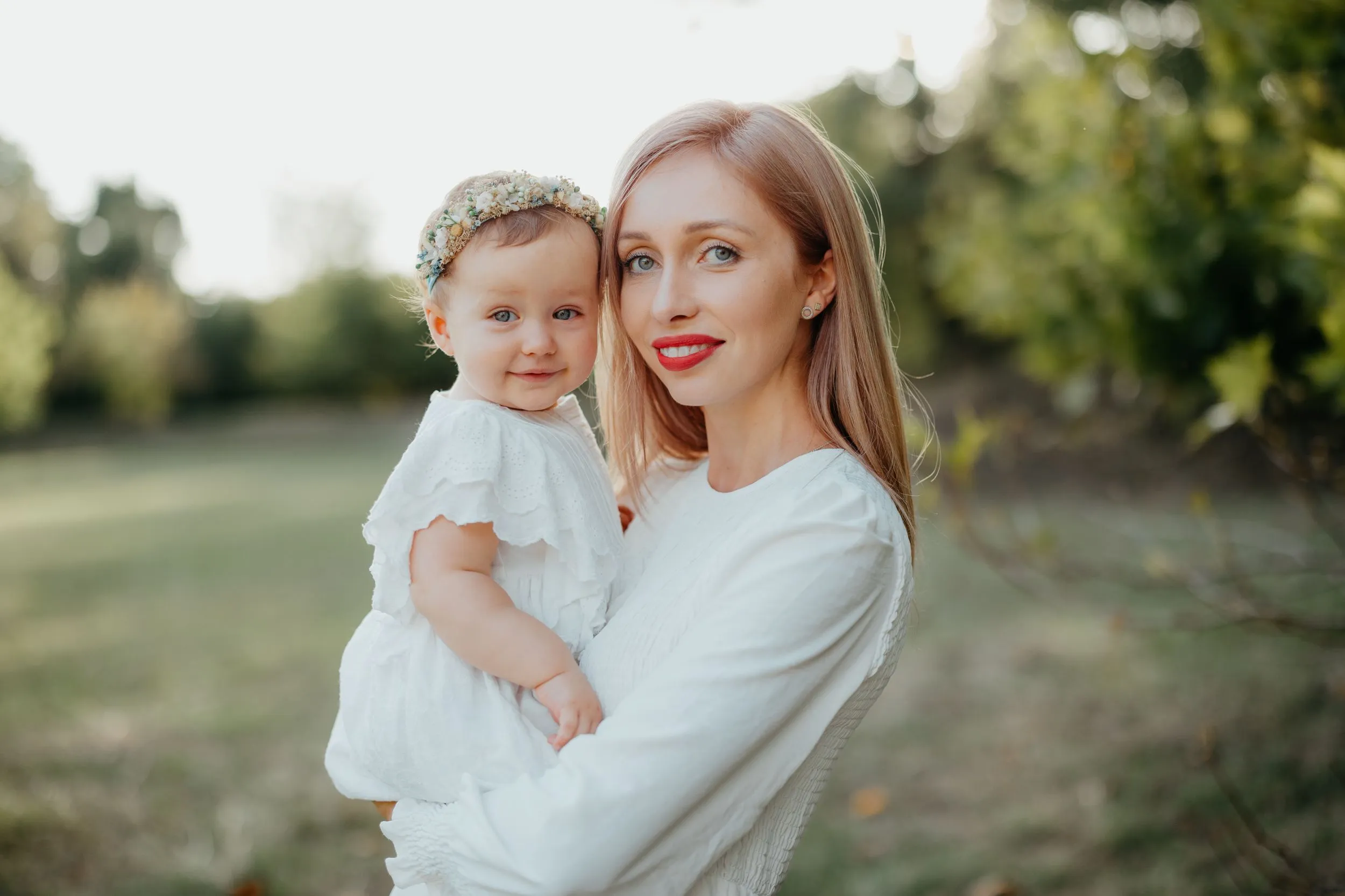 Nicole Wright holding her young daughter in golden evening light