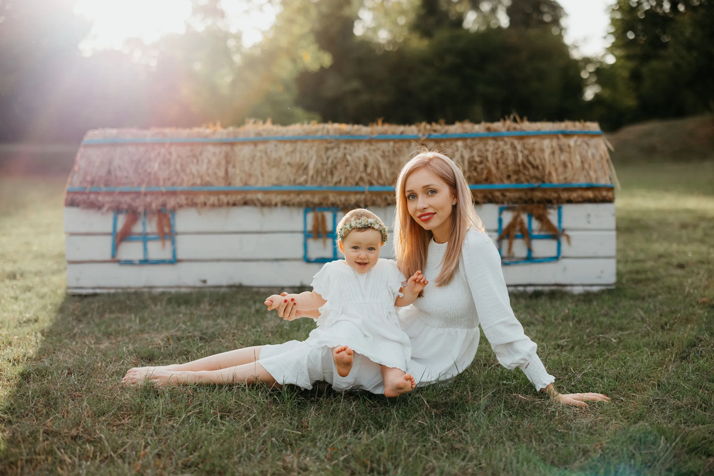 Mother and daughter sitting together in golden evening light
